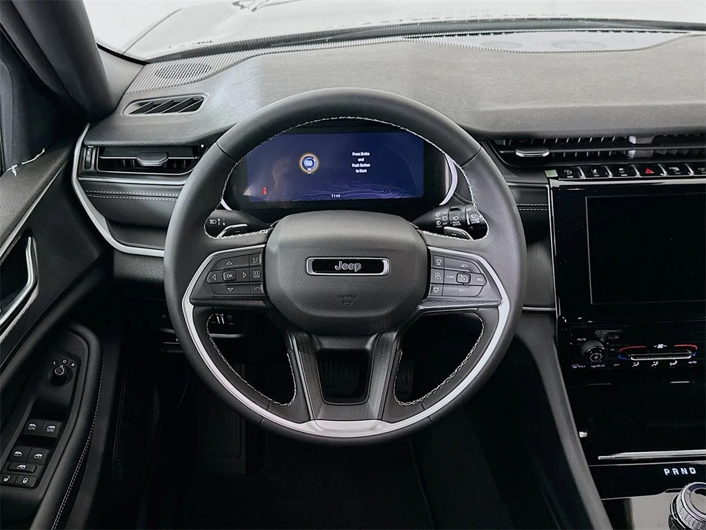 Close-up of Jeep steering wheel showing Adaptive Cruise Control (ACC) button on the right side